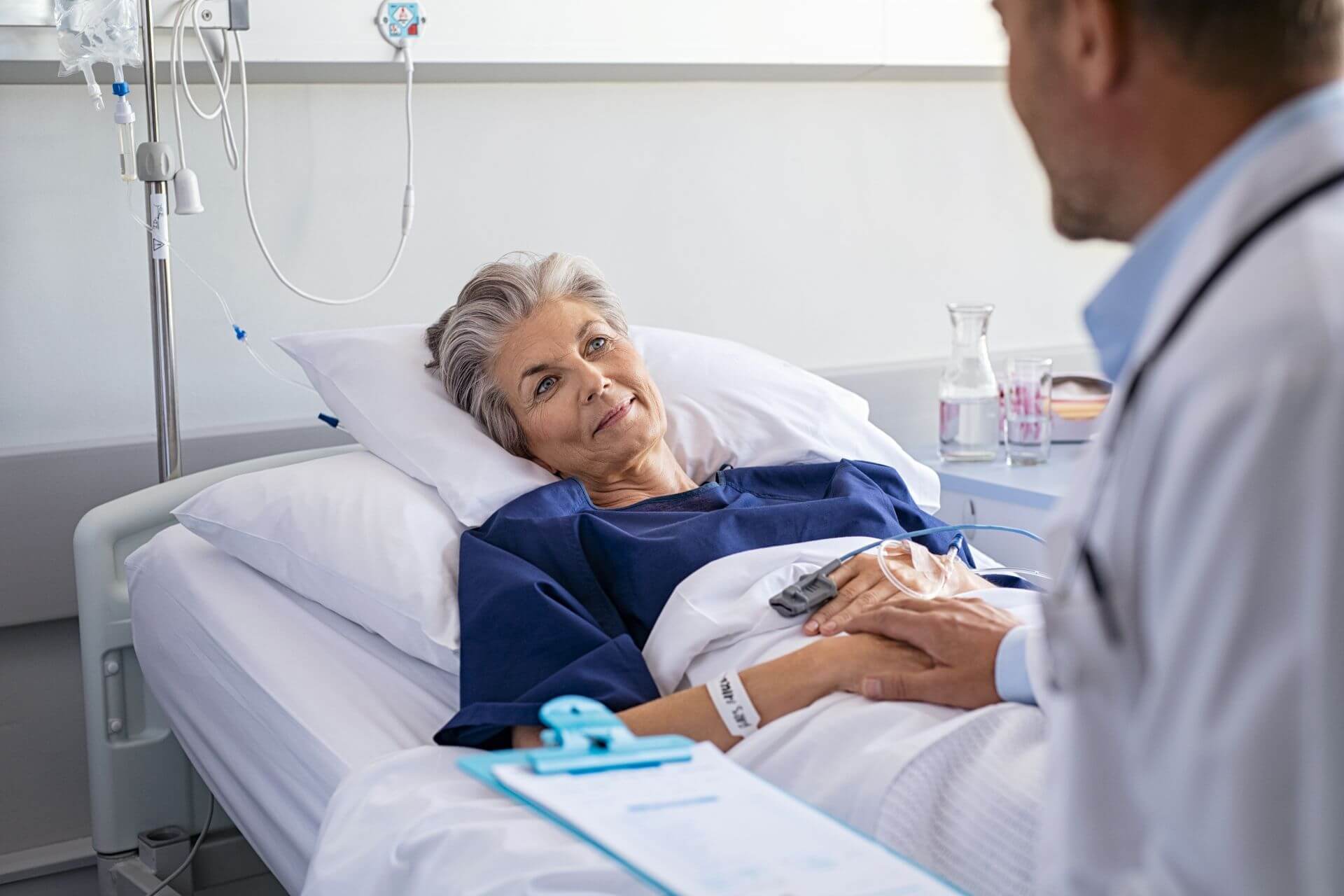Paziente ricoverata che dialoga con un professionista sanitario durante un percorso di cura specialistica.